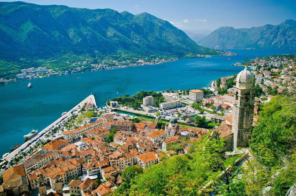 Uitzicht over de Baai van Kotor in Montenegro met oude stad, kerkkoepel en bergen tijdens 22-35ers reis Balkan.