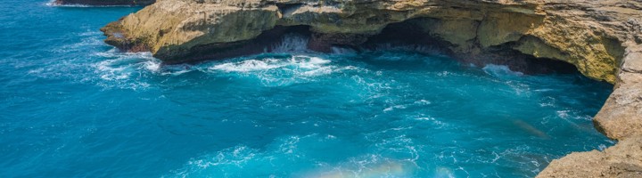 Rotskust bij Devil’s Tears op Nusa Lembongan met beukende golven en turquoise zee.