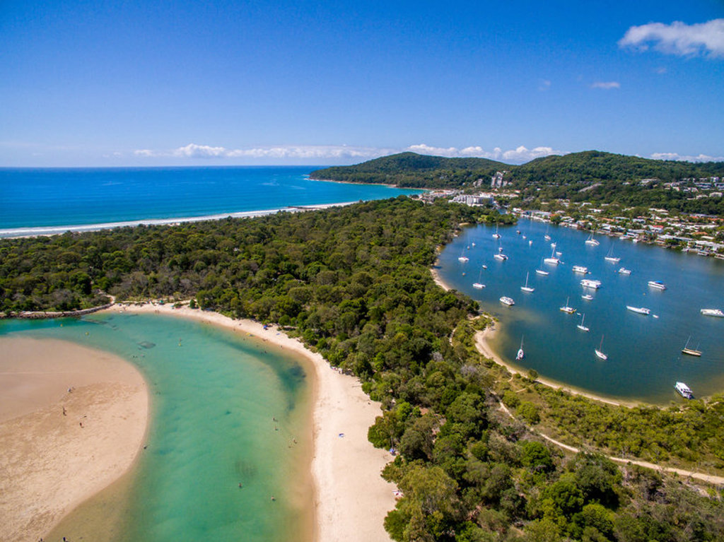 een strand en baai met zeilboten aan de kust van Australië tijdens een 22-35ers reis.