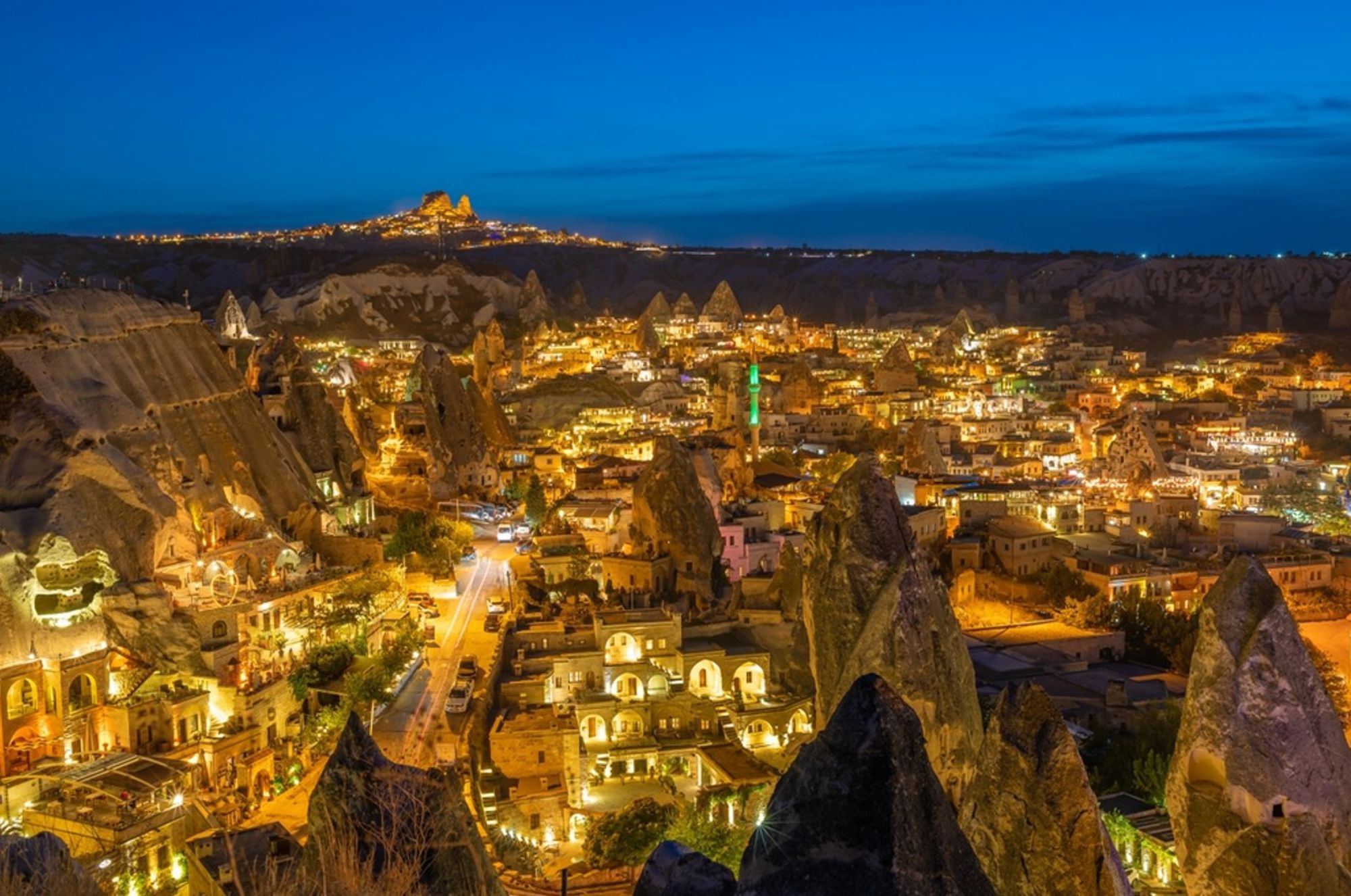 Avondzicht op Göreme in Cappadocië, Turkije, met verlichte huizen en karakteristieke rotsformaties.
