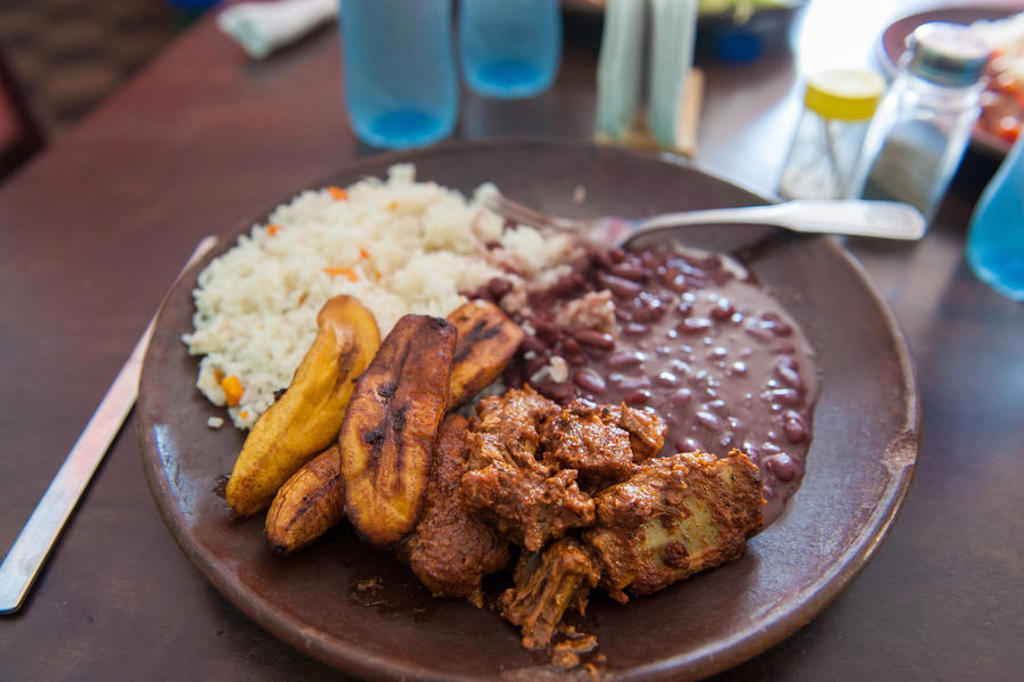 Traditionele maaltijd met rijst, zwarte bonen, gebakken bakbanaan en vlees tijdens groepsrondreis Nicaragua en Costa Rica.