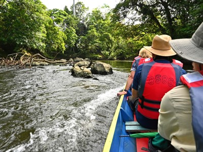 Boottocht over een rivier door het regenwoud van Maleisisch Borneo, met reizigers in reddingsvesten.