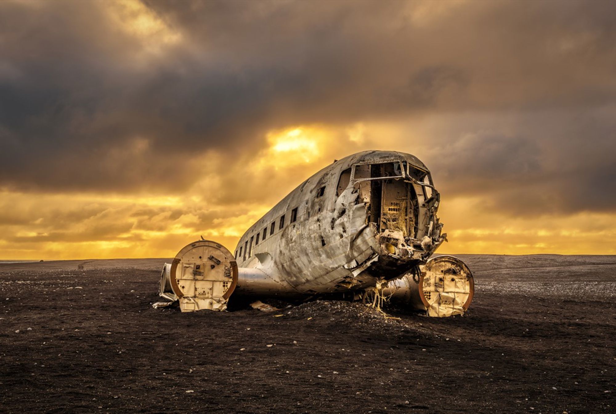 Vliegtuigwrak op het zwarte strand van Sólheimasandur in IJsland bij zonsondergang.
