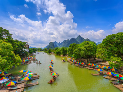 Bamboevlotten met kleurrijke parasols op de Li-rivier bij Guilin, met karstbergen op de achtergrond in China.