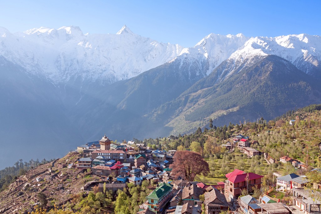 Bergdorp in Spiti met gekleurde huizen en besneeuwde Himalaya op de achtergrond tijdens groepsrondreis India.