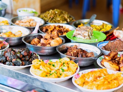 Vietnamese streetfoodkraam met schalen vol lokale gerechten op de Route Vietnam.