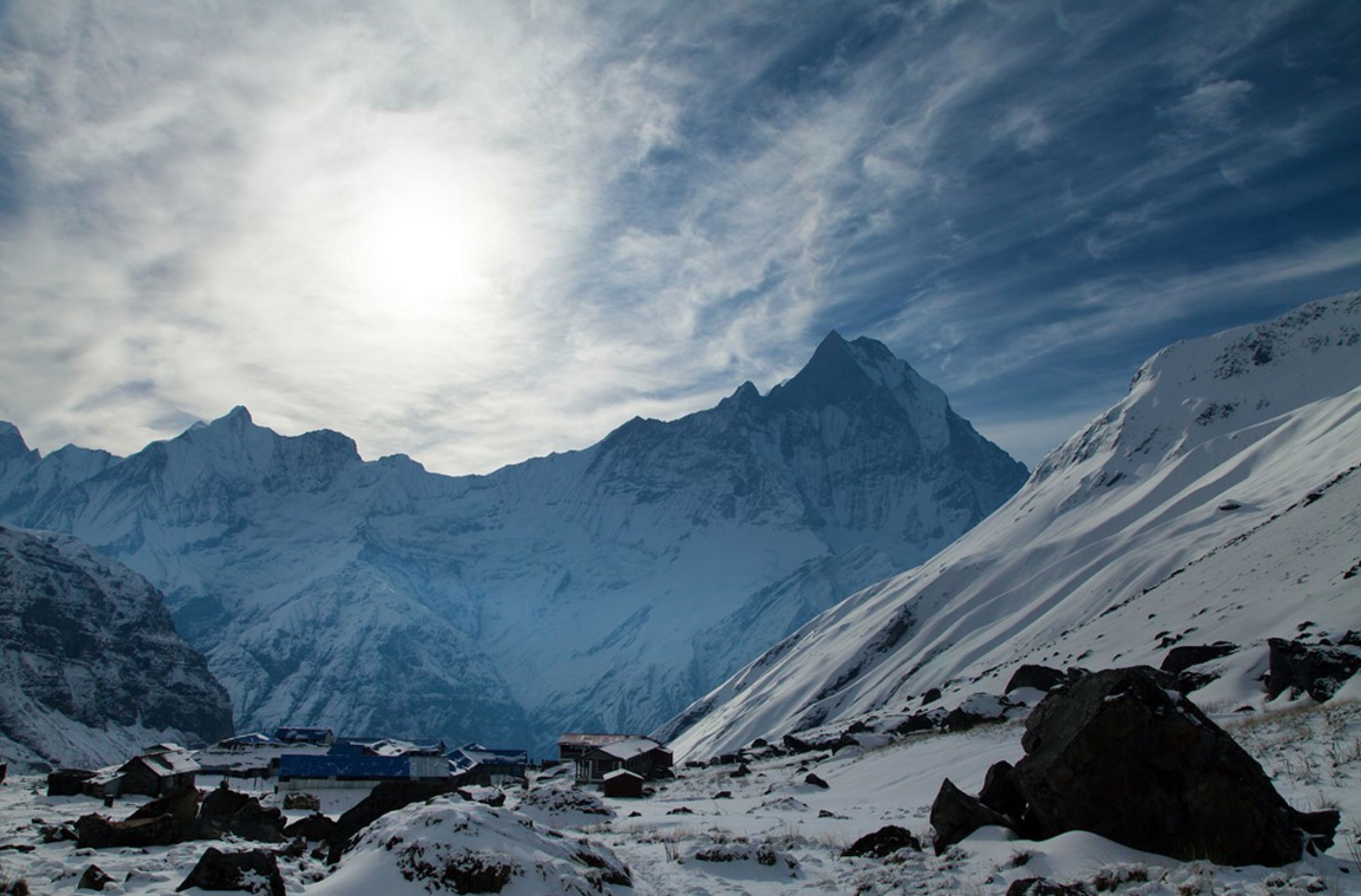 Besneeuwd berglandschap in Nepal met een bergdorp aan de voet van hoge Himalaya-toppen.