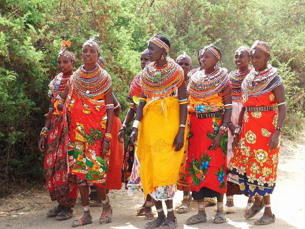 Groep Maasai-vrouwen in kleurrijke kleding en kralensieraden tijdens familiereis in Kenia, Tanzania en Zanzibar.