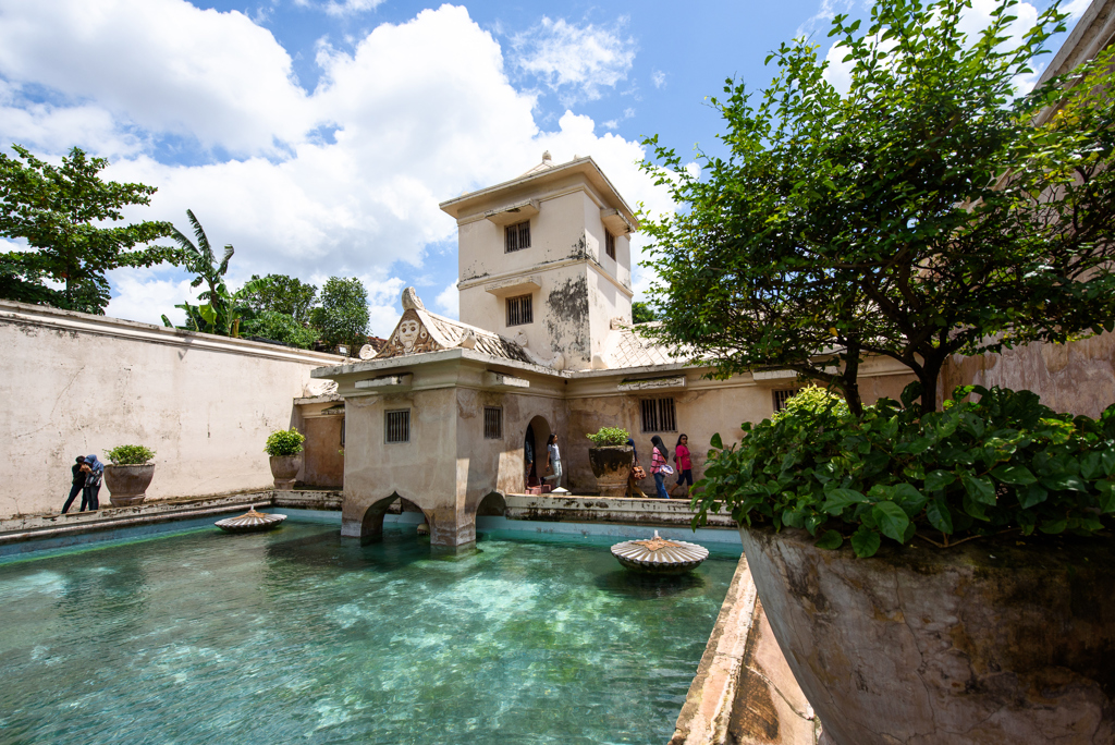 Waterpaleis Taman Sari in Yogyakarta, Java, met helderblauwe vijver en historische gebouwen.