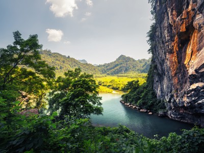 Groene rivier tussen kalkstenen kliffen en bergen op de Route Vietnam.