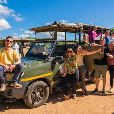 Groep 22-35ers bij safari-jeep tijdens rondreis door Zuid-Afrika.