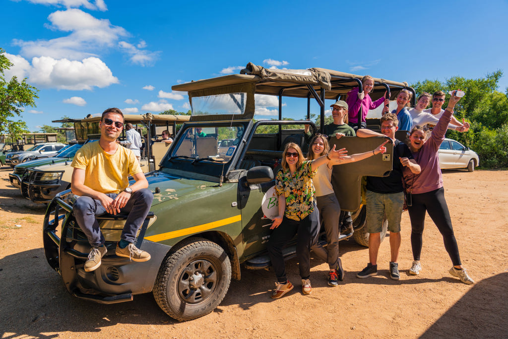 Groep 22-35ers bij safari-jeep tijdens rondreis door Zuid-Afrika.