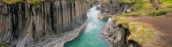 Stuðlagil Canyon in IJsland met basaltzuilen en een turquoise rivier.