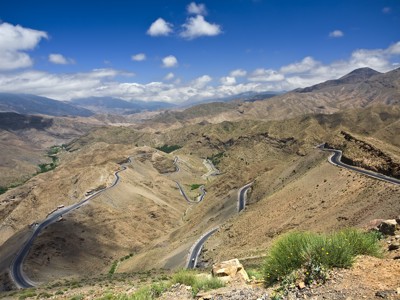 Panoramisch uitzicht op een slingerende bergweg in het Atlasgebergte tijdens de Route Marokko Familiereis.