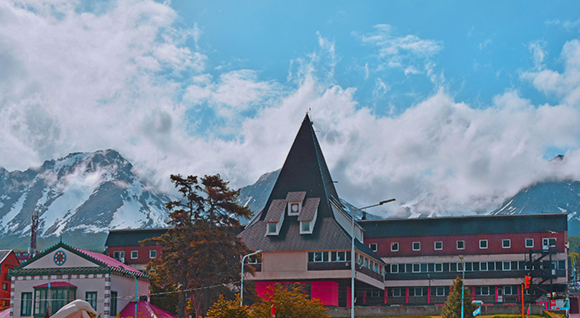 Stadsbeeld van Ushuaia met kleurrijke gebouwen en besneeuwde bergen op de achtergrond in Patagonië.