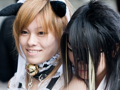 Twee cosplayers met kattenoortjes en kanten outfit tijdens een straatfestival in Japan.