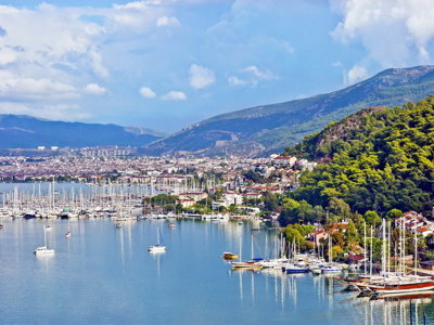 Jachthaven en kustplaats Fethiye aan de Turkse Rivièra, met zeilboten en bergen op de achtergrond.