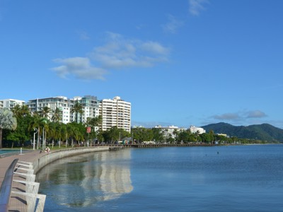 Boulevard langs de Esplanade Lagoon in Cairns met palmbomen, hotels en uitzicht over Trinity Bay.