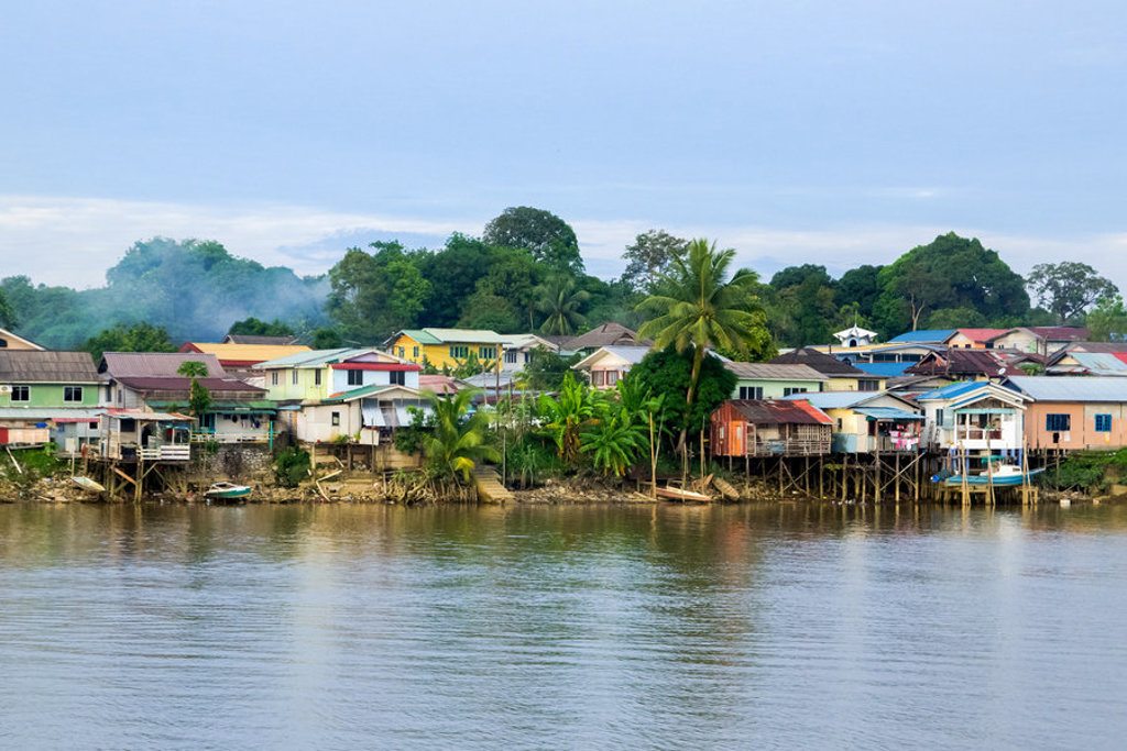 Kleurrijke paalwoningen langs een rivier in Borneo, Maleisië.