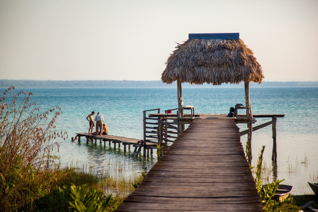 Houten steiger met rieten afdak aan het meer in Guatemala, geschikt voor familiereis Guatemala en Belize.