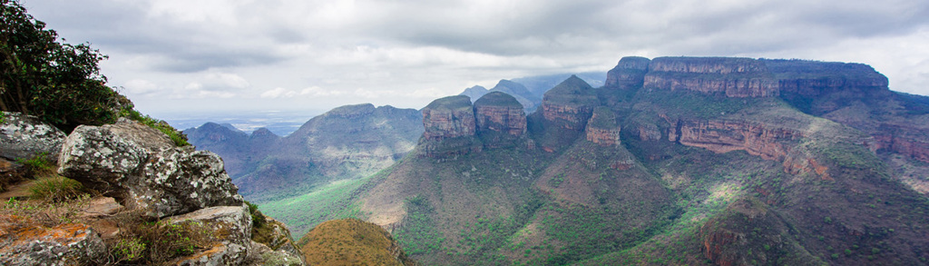 Uitzicht over de Blyde River Canyon in Noordelijk Zuid-Afrika, met groene valleien en rotsformaties onder bewolkte lucht.