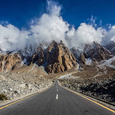 Weg door het Karakoramgebergte in Baltistan, Pakistan, met ruige bergtoppen en wolken.