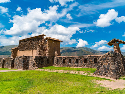 Inca-ruïnes van Raqchi met stenen muren en bergen onder blauwe lucht, route Peru.