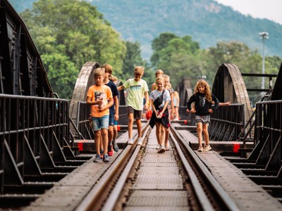 Kinderen lopen over de spoorbrug van de River Kwai bij Kanchanaburi, Thailand.