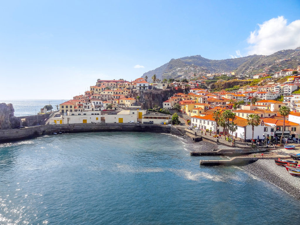 Kustdorp Câmara de Lobos op Madeira met kleurrijke huizen, haven en bergen op de achtergrond.