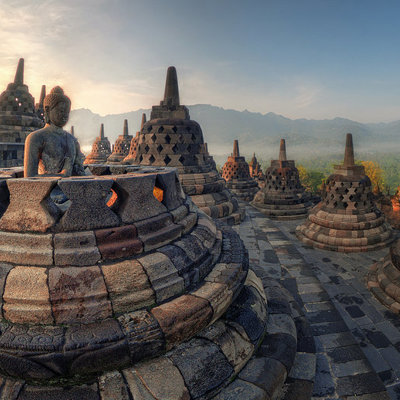 Zonsopkomst bij Borobudur-tempel op Java, met boeddhabeeld en stoepa’s tijdens groepsrondreis Java & Bali.