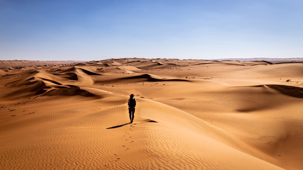 Wandelaar op hoge zandduinen in de Omaanse woestijn tijdens groepsrondreis Oman en Dubai.