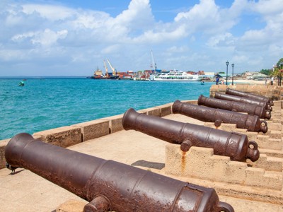 Oude kanonnen langs de kade van Stone Town, Zanzibar, met uitzicht op de haven en de Indische Oceaan.