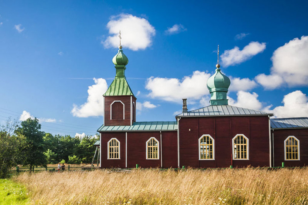 Houten kerk met groene koepels in Estland, Letland en Litouwen tijdens groepsrondreis.