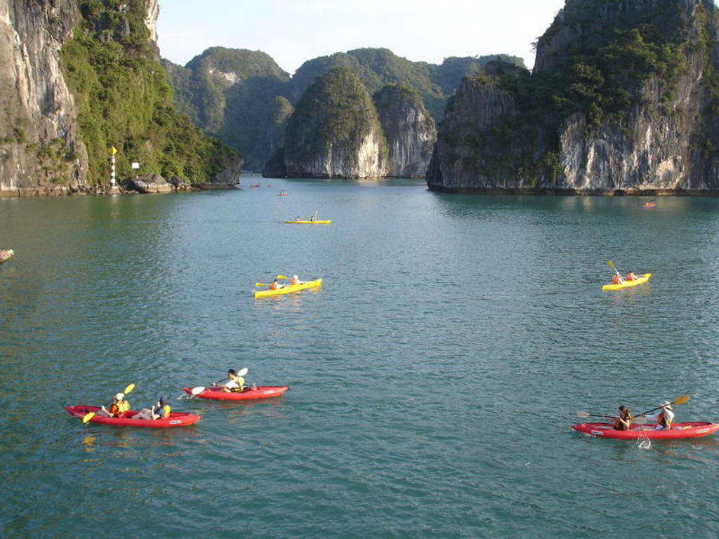 Kajakken tussen kalkstenen rotsen in Halong Bay tijdens een 22-35ers reis Vietnam.