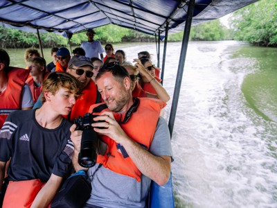 Reizigers met reddingsvesten varen per boot door de mangroven tijdens de Route Costa Rica, dag 4.