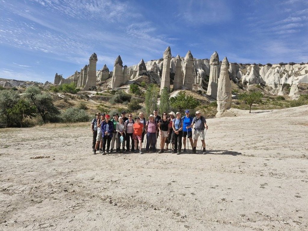 Wandelaars op een rotsig pad met uitzicht op de rotsformaties van Cappadocië, Turkije.