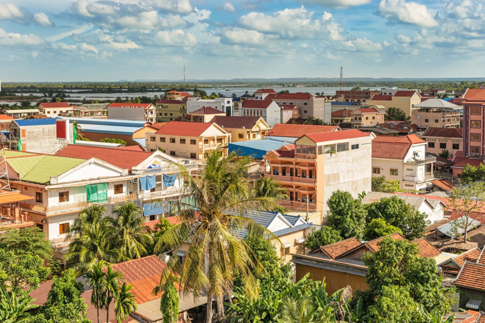 Uitzicht over Siem Reap in Cambodja met kleurrijke daken, palmbomen en de rivier in de verte.