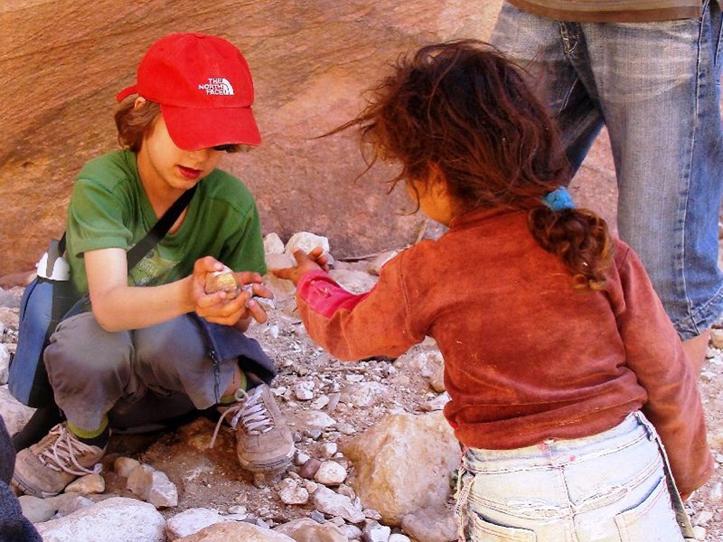 Kinderen spelen met stenen tijdens een familiereis in Jordanië.
