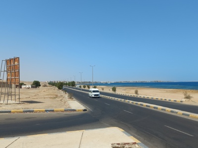Kustweg langs de Rode Zee tijdens Route Egypte, met busje op de weg en woestijnlandschap.