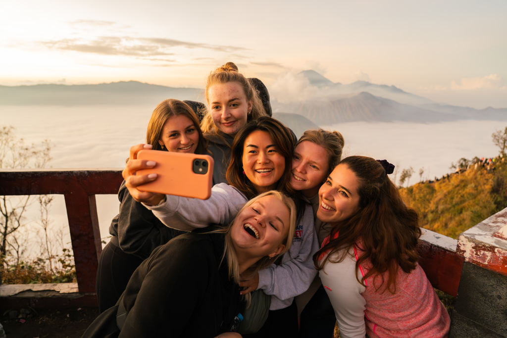 Vriendengroep maakt selfie met vulkaanlandschap bij zonsopkomst tijdens 22-35ers reis Indonesië Java en Bali.