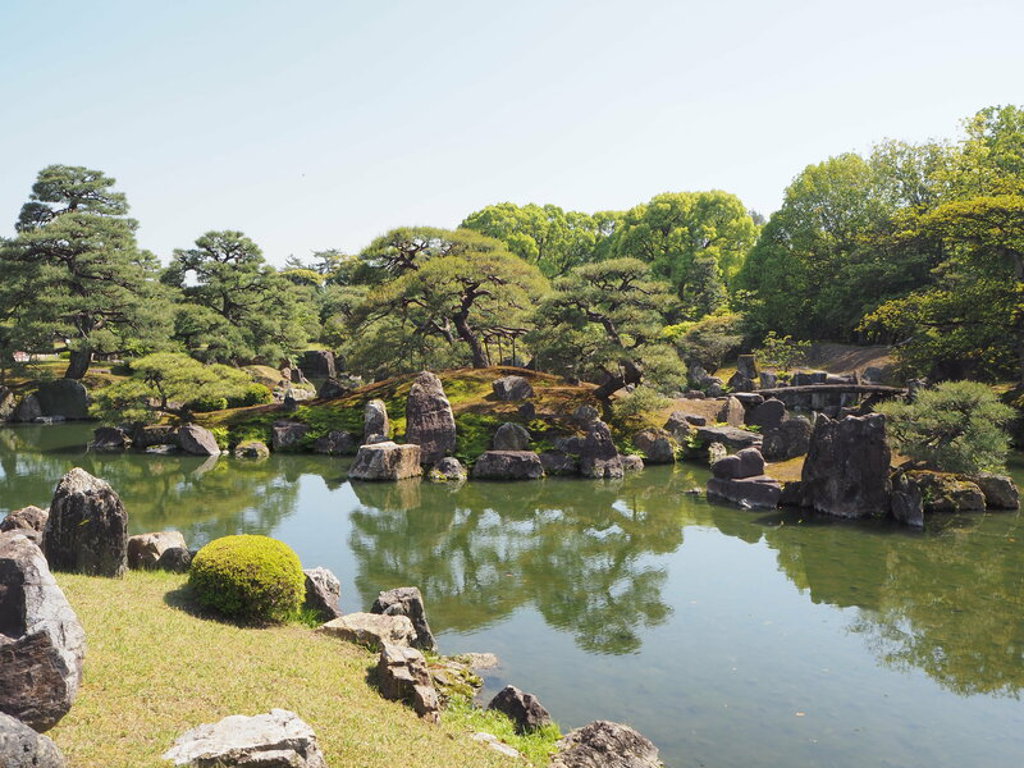 Japanse tuin met vijver, rotsen en pijnbomen tijdens een 22-35ers reis Japan.