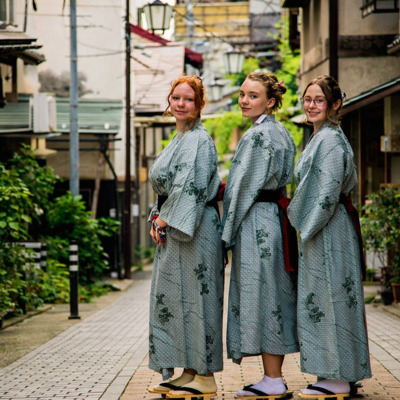 Drie vrouwen in yukata op een smalle straat in Japan.
