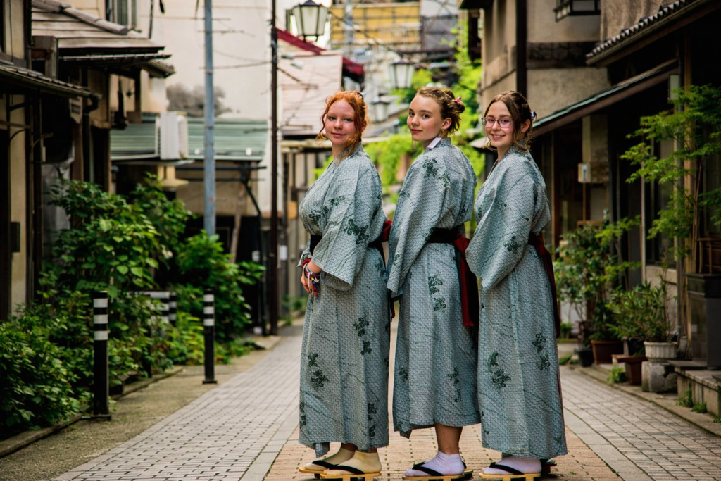 Drie vrouwen in yukata op een smalle straat in Japan.