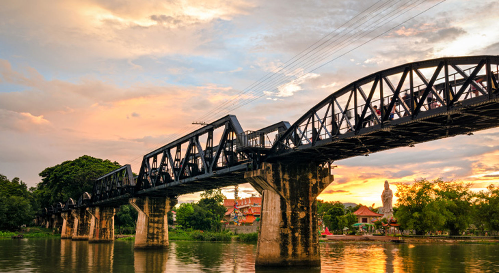 Brug over de rivier Kwai bij zonsondergang in Kanchanaburi, Thailand.