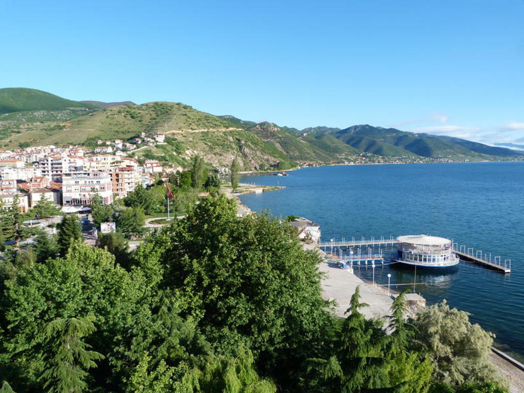 Uitzicht op Pogradec aan het Ohridmeer met boulevard en bergen, tijdens groepsrondreis Albanië, Kosovo en Noord-Macedonië.
