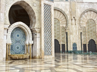 Binnenplaats van de Hassan II-moskee in Casablanca met mozaïektegels, bogen en marmeren vloer.