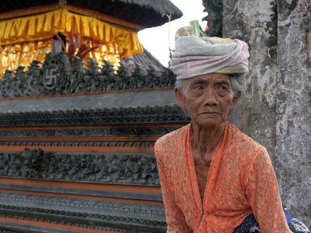 Balinese vrouw in traditionele kleding bij een tempel op Bali tijdens familiereis Java & Bali.