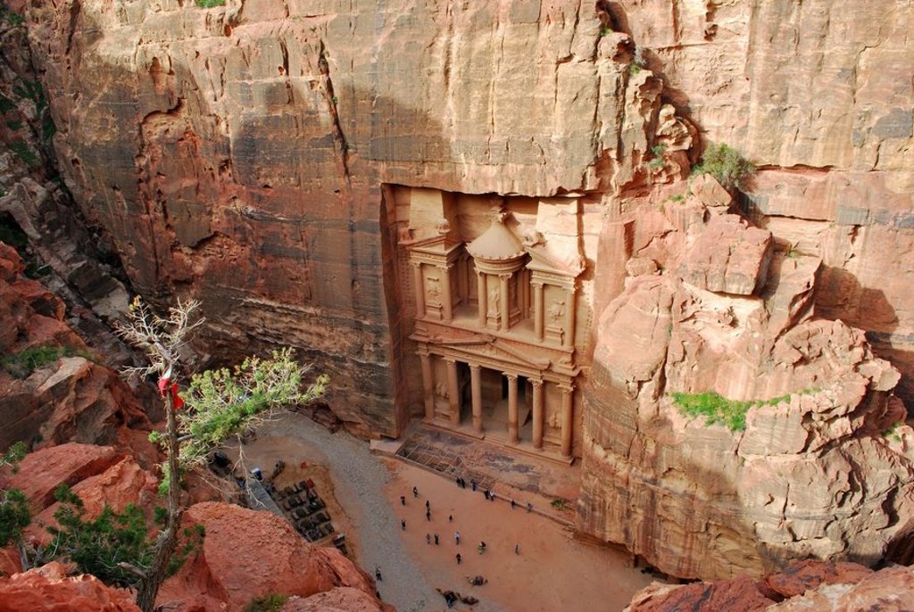 Groepsrondreis Jordanië hoogtepunten: kamelen in de Wadi Rum-woestijn met rotsformaties op de achtergrond.
