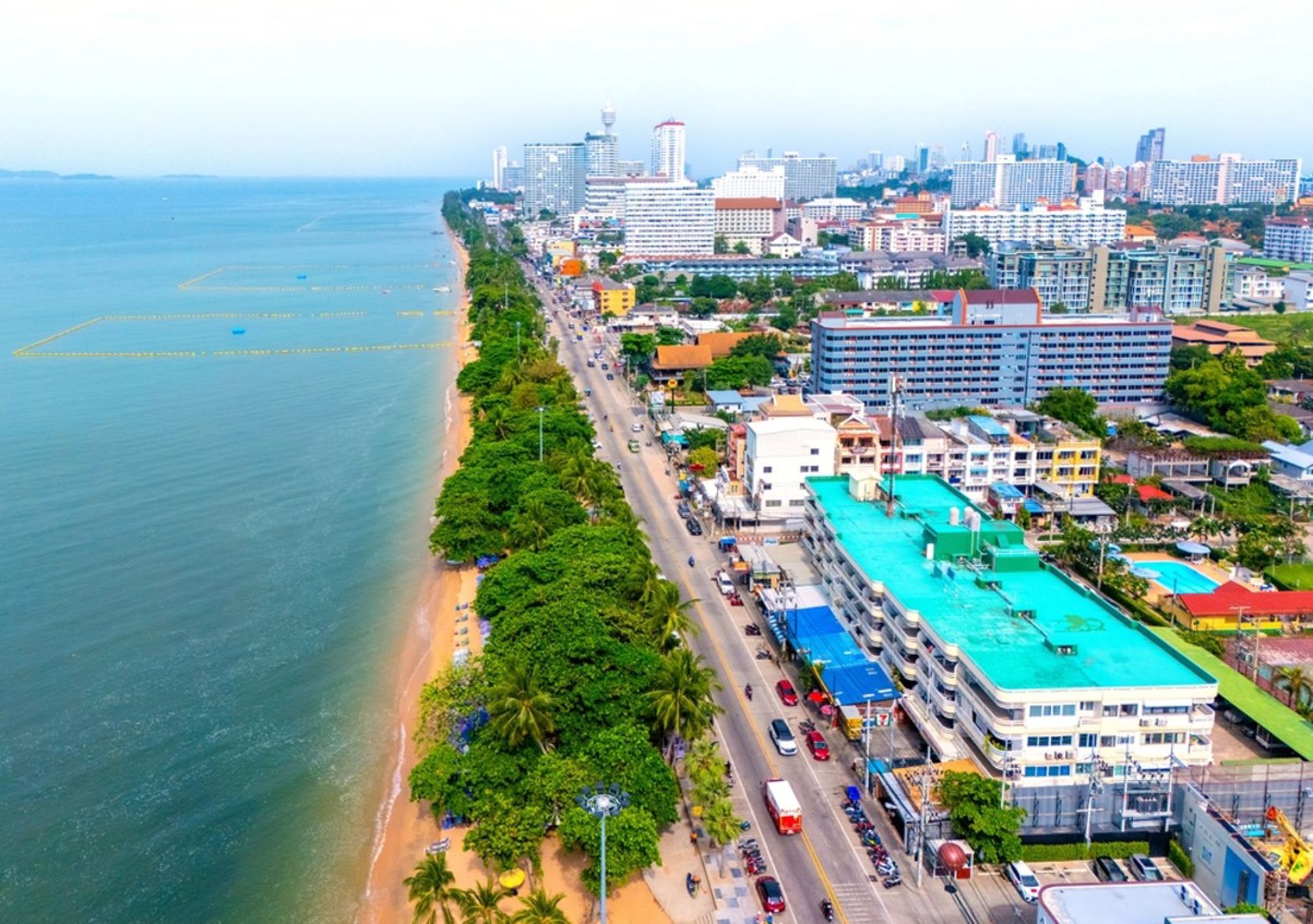Pattaya Beach met strandboulevard, palmbomen en skyline aan de Golf van Thailand.