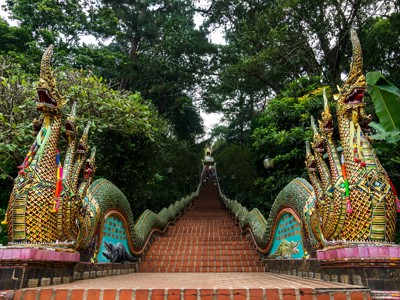 Trap naar Doi Suthep-tempel in Chiang Mai met kleurrijke naga-slangen langs de balustrade.